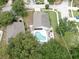 An aerial view showcases this property's refreshing private pool, patio area, and fenced yard surrounded by mature trees at 11302 Crane Lake Ct, Riverview, FL 33569