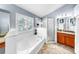 Bright bathroom features a soaking tub, tiled shower with glass door, and stylish vanity with granite countertops at 11302 Crane Lake Ct, Riverview, FL 33569