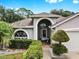 The entryway features an arched window and neutral paint that enhances curb appeal at 11302 Crane Lake Ct, Riverview, FL 33569