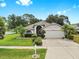 Attractive single-story home with a two-car garage, manicured landscaping, and a well-maintained lawn at 11302 Crane Lake Ct, Riverview, FL 33569