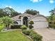 Charming single-story home featuring a well-manicured lawn and a two-car garage, all illuminated by landscape lighting at 11302 Crane Lake Ct, Riverview, FL 33569