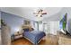 Cozy main bedroom features a ceiling fan, neutral walls, hardwood floors, and a view to the attached bathroom at 11302 Crane Lake Ct, Riverview, FL 33569