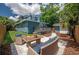 Backyard featuring a well-manicured lawn, deck, paver patio, seating and lovely landscaping at 1203 E 33Rd Ave, Tampa, FL 33603