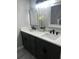 Modern bathroom featuring double sinks, sleek countertops, and stylish mirrors with updated lighting at 12415 Stagecoach Ln, Hudson, FL 34667