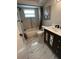 Modern bathroom features marble tile, soaking tub, and elegant vanity with black fixtures at 12415 Stagecoach Ln, Hudson, FL 34667