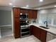 Traditional kitchen with dark cabinets, stainless steel appliances, and bright, natural light from the window at 12415 Stagecoach Ln, Hudson, FL 34667