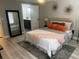 Comfortable bedroom with a queen-sized bed, modern decor, and an ensuite bathroom with dark-gray cabinets at 12415 Stagecoach Ln, Hudson, FL 34667