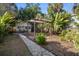 Expansive backyard showcases a stone walkway, garden pergola, and leads to the house with patio seating at 132 21St S Ave, St Petersburg, FL 33705