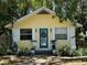 Charming yellow home featuring a teal door and landscaped front yard at 132 21St S Ave, St Petersburg, FL 33705