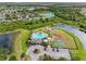 Aerial view of community amenities including a pool, playground and parking area surrounded by natural landscape at 13313 Ashbark Ct, Riverview, FL 33579