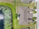 A bird's eye view of a home reveals a well maintained roof, landscaping, and pond at 13313 Ashbark Ct, Riverview, FL 33579
