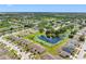 An aerial view captures a vibrant neighborhood, showcasing lush greenery, serene ponds, and cozy homes at 13313 Ashbark Ct, Riverview, FL 33579
