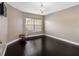 Bedroom with dark wood floors, white trim, chandelier and a window that lets in natural light at 13313 Ashbark Ct, Riverview, FL 33579