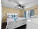 A Primary bedroom with a queen bed, ceiling fan, blue curtains, and wood floors at 13313 Ashbark Ct, Riverview, FL 33579