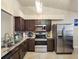Modern kitchen features stainless steel appliances, beautiful countertops and cabinetry, and tile flooring at 13313 Ashbark Ct, Riverview, FL 33579