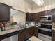 A spacious kitchen showcases stainless steel appliances, granite countertops, and brown wooden cabinetry at 13313 Ashbark Ct, Riverview, FL 33579