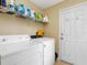 The laundry room features a washer and dryer and storage shelving for supplies at 13313 Ashbark Ct, Riverview, FL 33579