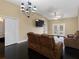An open living room with hardwood floors, modern lighting, and comfortable sofa and seating at 13313 Ashbark Ct, Riverview, FL 33579