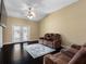 Bright living room with dark wood floors, fan, and french doors that let in tons of light at 13313 Ashbark Ct, Riverview, FL 33579
