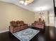 Spacious living room featuring dark wood floors, stylish furniture, ceiling fan, and elegant decor at 13313 Ashbark Ct, Riverview, FL 33579