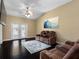 Bright living room with dark wood floors, fan, and french doors that let in tons of light at 13313 Ashbark Ct, Riverview, FL 33579