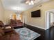 Open living room boasts dark wood floors, fan, and stylish furniture, with view of dining area and kitchen at 13313 Ashbark Ct, Riverview, FL 33579