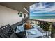 Cozy balcony with table setting and scenic views of the ocean and sandy beach at 1600 Gulf Blvd # 514, Clearwater Beach, FL 33767