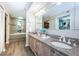 Bathroom with dual sinks, granite countertops, a large mirror, a soaking tub, and a walk-in closet at 1600 Gulf Blvd # 514, Clearwater Beach, FL 33767