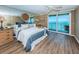 Bright bedroom featuring wood floors, a large mirror, and a sliding door to a balcony with ocean views at 1600 Gulf Blvd # 514, Clearwater Beach, FL 33767