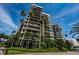 A modern multi-story condo building framed by lush tropical foliage and palm trees at 1600 Gulf Blvd # 514, Clearwater Beach, FL 33767