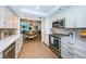 Modern kitchen offering stainless appliances, bright cabinets, tile backsplash, and an adjacent dining area at 1600 Gulf Blvd # 514, Clearwater Beach, FL 33767