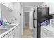 Compact kitchen featuring white cabinets, appliances, and tile flooring at 1799 N Highland Ave # 180, Clearwater, FL 33755
