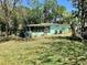 Lush backyard featuring ample greenery, mature trees, and a screened-in porch for relaxing and entertaining at 1810 Alcorn Rd, Valrico, FL 33596