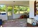 Enclosed porch with views of the landscaped backyard and a table with chairs at 1810 Alcorn Rd, Valrico, FL 33596