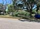 Well-kept, one-story home with mature trees, nice landscaping, and a blue car parked on the street at 1810 Alcorn Rd, Valrico, FL 33596