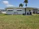 View of the backyard featuring well-maintained grass and a small covered patio area at 18675 Us Highway 19 N # 318, Clearwater, FL 33764