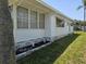 Side view of the home highlighting the well-kept lawn, garden bed, and neutral siding at 18675 Us Highway 19 N # 318, Clearwater, FL 33764