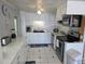 Bright kitchen featuring white cabinetry, stainless steel appliances, and a classic tile floor at 18675 Us Highway 19 N # 318, Clearwater, FL 33764