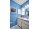 Bathroom featuring a vanity, a decorative mirror, and bright blue walls at 2113 Malcolm Dr, Palm Harbor, FL 34684
