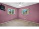 Bedroom with mauve colored walls, neutral carpets, and two large windows at 2113 Malcolm Dr, Palm Harbor, FL 34684