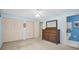 Bright bedroom featuring a wooden dresser and large closets for ample storage at 2113 Malcolm Dr, Palm Harbor, FL 34684
