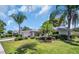 Beautiful single-story home with well-manicured lawn and landscaping, including tropical palm trees at 2113 Malcolm Dr, Palm Harbor, FL 34684