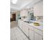 Bright kitchen with white countertops, cabinets, tile flooring and stainless steel sink at 2113 Malcolm Dr, Palm Harbor, FL 34684