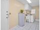 Laundry room with washer, utility sink, storage cabinets, and tile flooring at 2113 Malcolm Dr, Palm Harbor, FL 34684