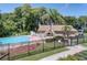 A gated community pool area with a pristine pool, lounge chairs, and a recreation building surrounded by lush landscaping at 2113 Malcolm Dr, Palm Harbor, FL 34684