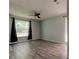 Bright bedroom featuring sleek flooring, ceiling fan, and large windows for ample natural light at 2380 Shelly Dr # B, Palm Harbor, FL 34684