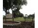 Highland Lakes Golf Club with a sign, bench, trees, and manicured lawn at 2380 Shelly Dr # B, Palm Harbor, FL 34684