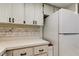 Well-lit kitchen featuring a white refrigerator and matching white cabinets at 2380 Shelly Dr # B, Palm Harbor, FL 34684