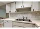 Kitchen featuring a stainless steel sink, white dishwasher, and updated backsplash at 2380 Shelly Dr # B, Palm Harbor, FL 34684