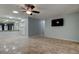 Bright and open living room with tiled floors, a mounted TV, and kitchen bar at 2380 Shelly Dr # B, Palm Harbor, FL 34684
